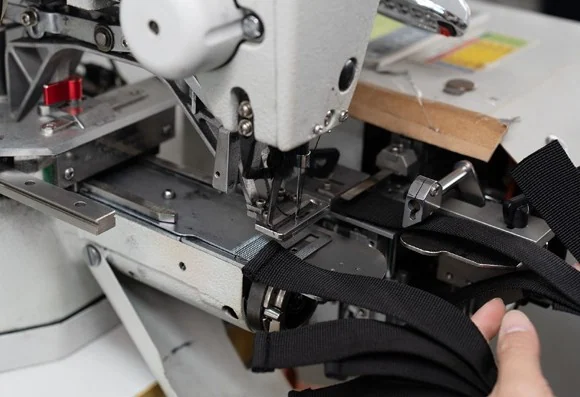 Close-up of carry webbing being reinforced on a sewing machine